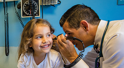 Doctor looking into a pediatric patients ear