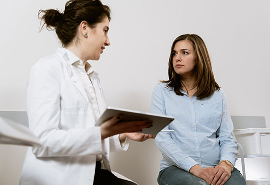 Female patient speaking with her female provider in an exam room