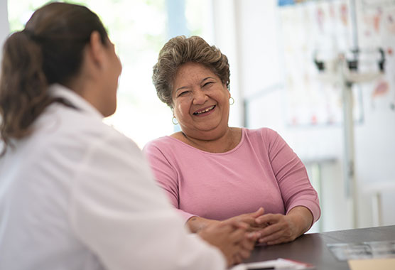 Older woman smiling while talking to health care provider