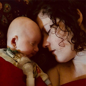 Woman and baby facing each other sleeping