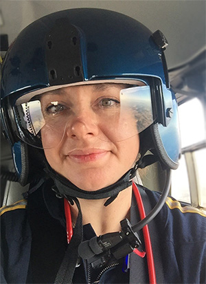 A member of the UC Davis Transport team wearing a helmet in a helicopter