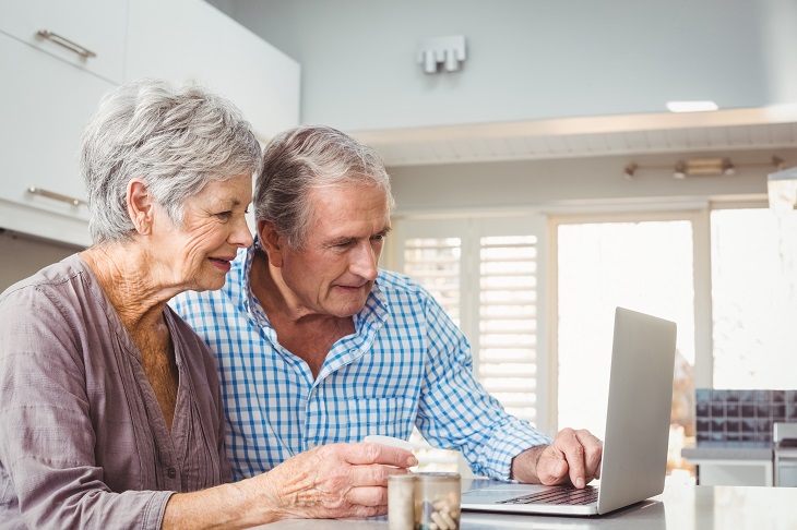 two aging adults viewing laptop screen together
