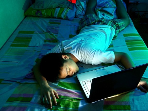 teen sleeping in front of laptop