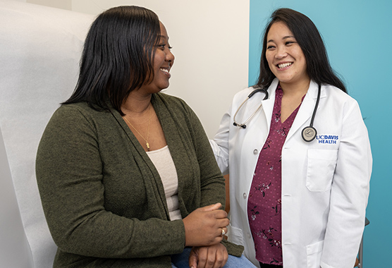 Dr. with female patient in an exam room