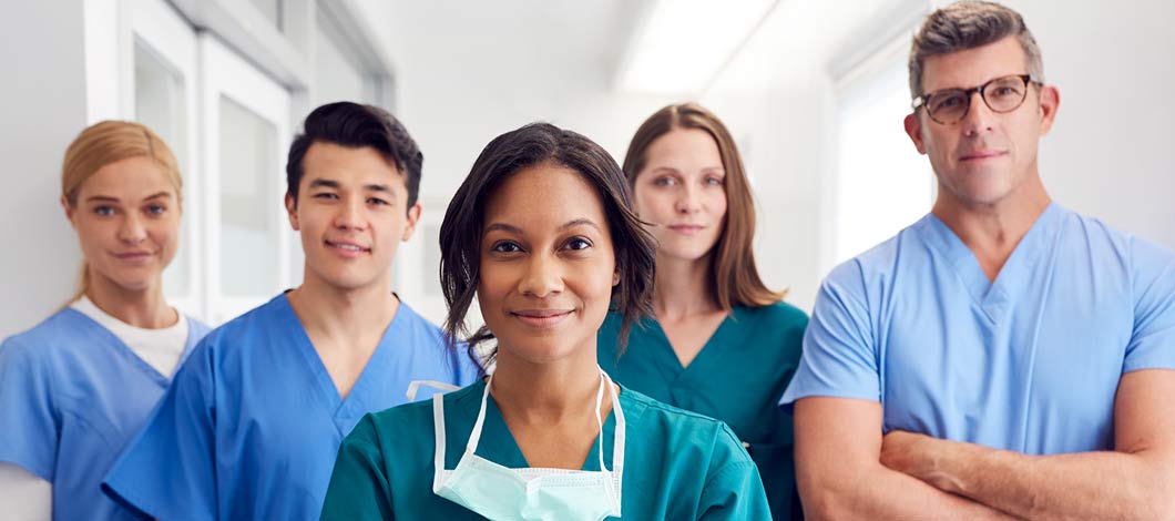 Physicians and nurses standing in a hospital hallway