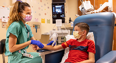 nurse uses ultrasound equipment to better see a child’s veins when placing an IV