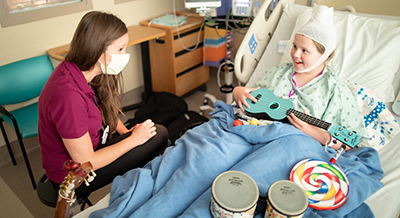 Child life specialist and a patient during music therapy