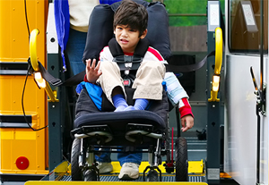 Disabled boy in a wheelchair on a bus.