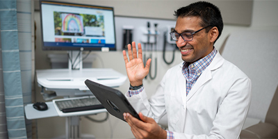 Dr. Vinu Ninan conducts a telehealth visit on a tablet. (c) UC Davis Regents. All rights reserved.