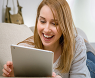 Woman smiling at tablet.