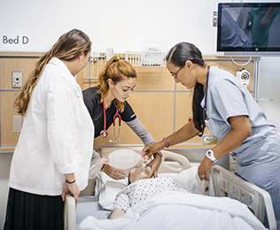 Physician and nurses practicing on a simulation doll