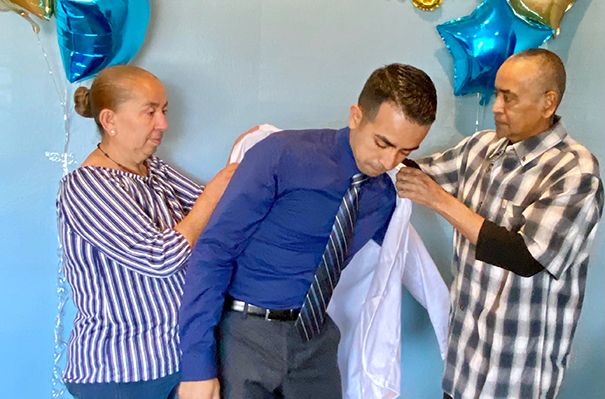 Alex Villegas and his family helping him put on his whitecoat