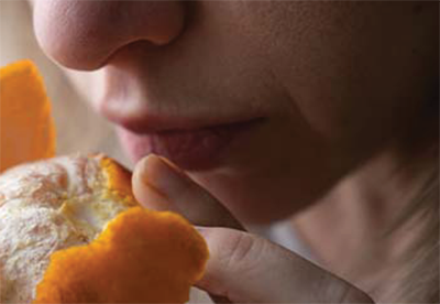 Person smelling an orange