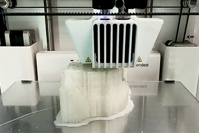 A 3D printer operating to create a portion of a model skull.