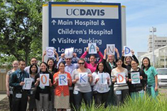 Employees standing in front of UC Davis sign