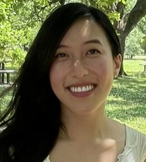 A portrait of Lauren Nguyen taken outdoor with greenery in the background.