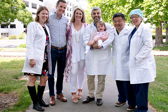 Patient Evie Harden with parents and care team on lawn at UC Davis
