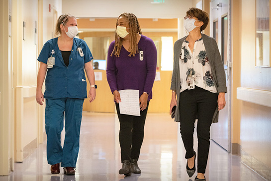 Three medical social workers walking down the hallway at the children's hospital.