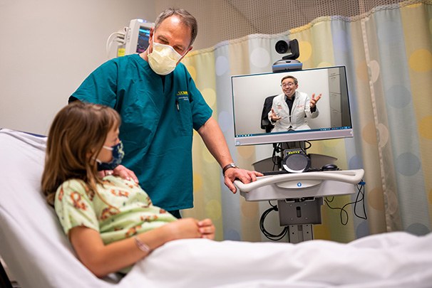 Dr. Marcin and telehealth physician assisting patient
