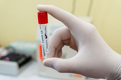 A hand holding a sealed test tube.