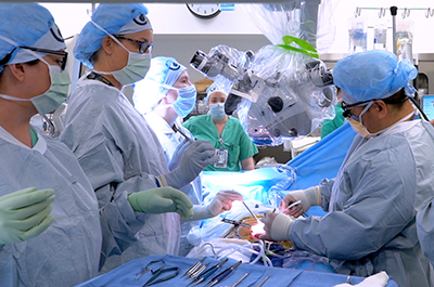 Doctors and nurses working together on a patient in an operating room.