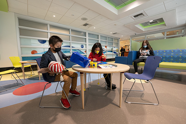 Children sitting at a table in the pediatric ED waiting room