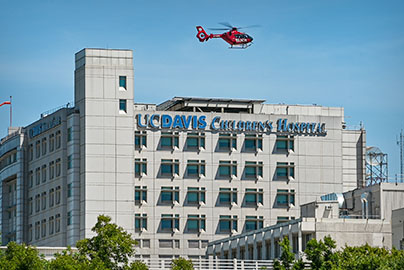 UC Children's Hospital building with helicoptor transport flying above it
