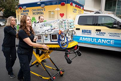 Neonatal transport nurses pushing bed from UC Davis Children's Hospital ambulance