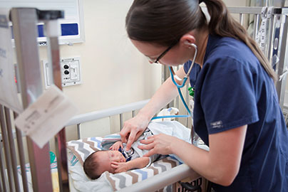 Nurse checking in on baby in NICU