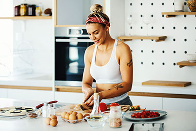 Young adolescent female in kitchen preparing whole foods