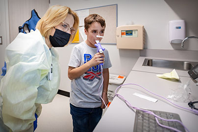 pediatric patient taking spirometry test with respiratory therapist