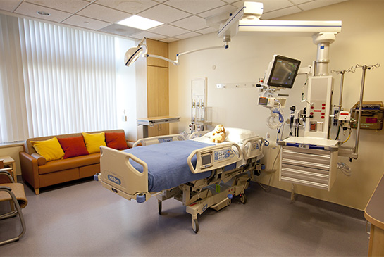PICU room with bed, sleeping sofa and a chair.