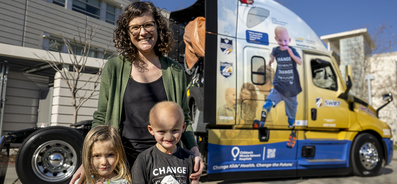Shine Duby and his family posing with a semitruck