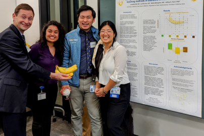 Jeffrey Hoch, interim director of CHPR, smiles with first year medical students and their poster at Applied Public Health Research Day.