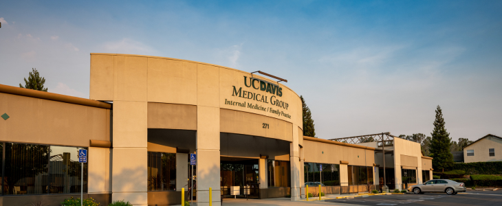 The front entrance of the UC Davis Health Folsom Clinic, a one story building next to a parking lot. 