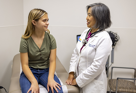 A doctor and patient look at a tablet together.
