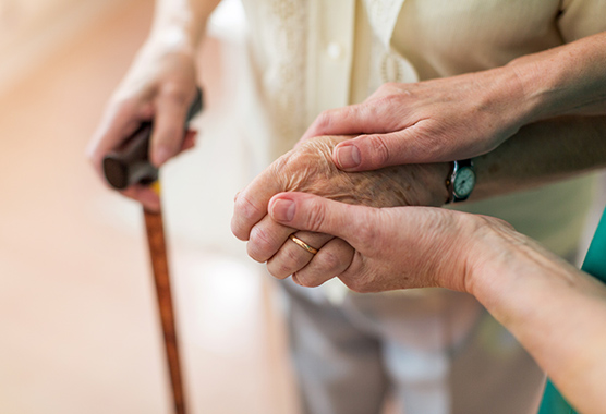 Holding hands of person with Alzheimer’s Disease