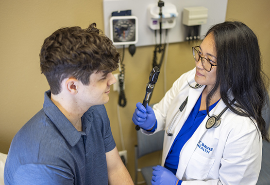 A doctor examines a patient's eye using an ophthalmoscope.