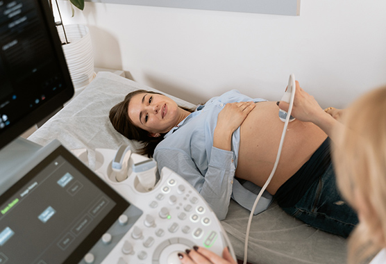 Pregnant woman receiving an ultrasound at a health care office