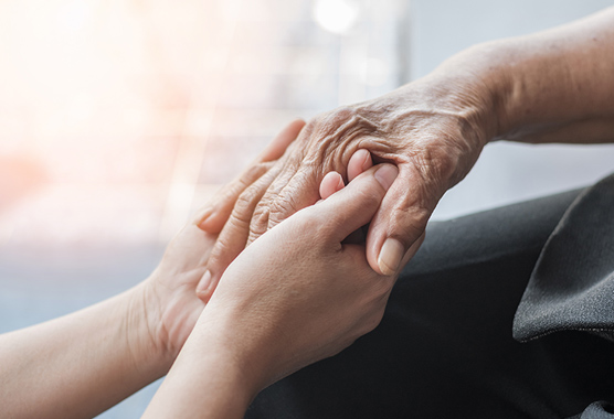 One person holding hands with another person with arthritis.