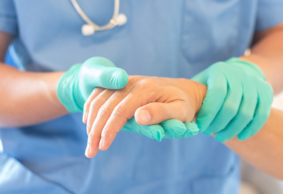Hand specialist looking at person with hand trauma.