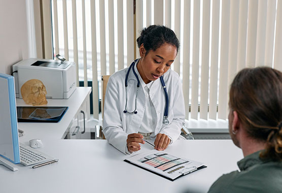 Female health care provider sitting at a desk talking to a patient