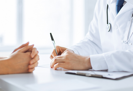 Health care provider’s hands on a table across from patient’s hands discussing HIV.