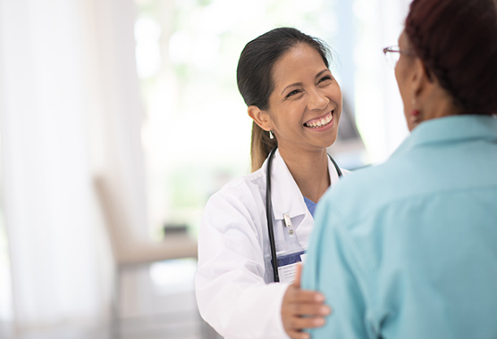 Female health care provider discussing hyperthyroidism with patient.