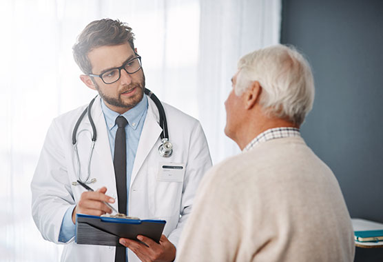 Male health care provider talking to older man