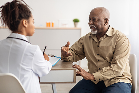 Male patient talking to female health care provider at a desk