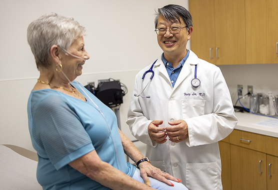 Older female patient speaking with a male doctor.