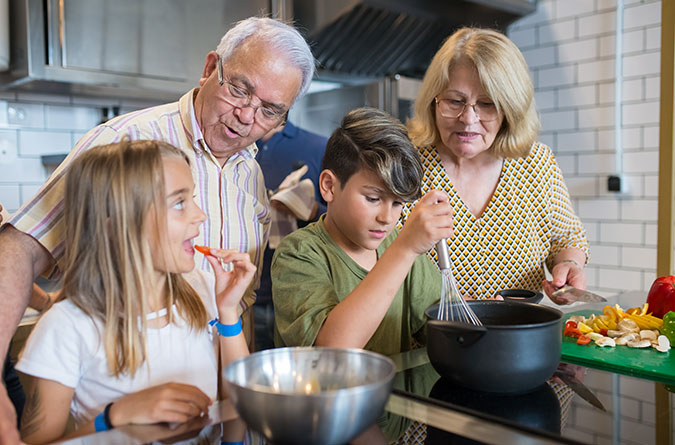 Grandparents cooking with their grandson and granddaughter