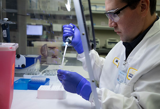 Male scientist using lab testing equipment