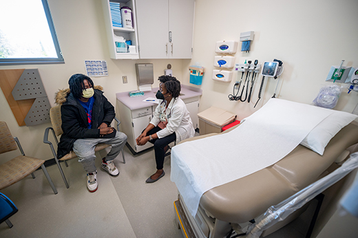Male patient sitting in a treatment room speaking to a female doctor